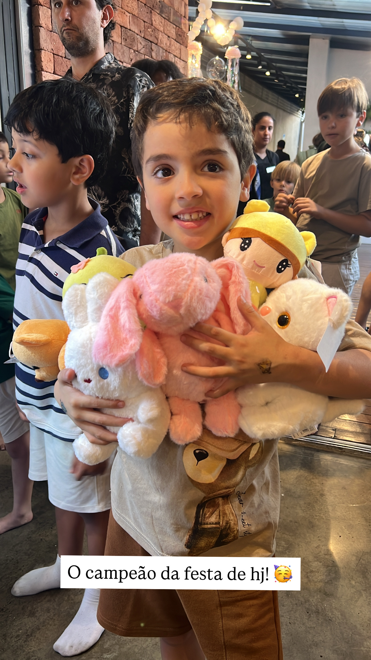 Criança feliz com pelúcias conquistadas